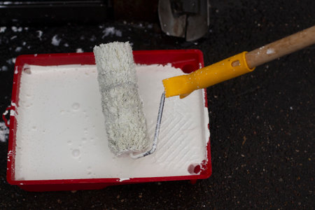 White paint in the container. Roller with paint to paint the wall.の写真素材