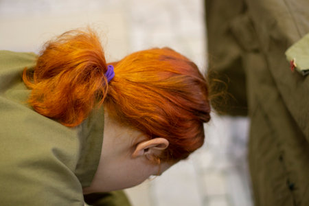 The girl's red hair. The hair is collected in a ponytail. Red-colored hair.の写真素材