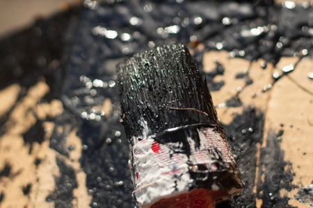 Black paint on a brush and in a bucket. Outdoor painting with waterproof paint.の写真素材