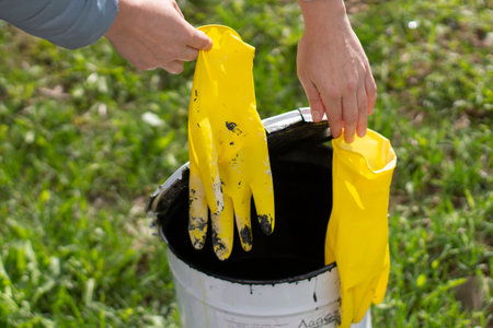 Yellow gloves and a bucket of paint. Working gloves in hand. The beginning of repairs in the house....