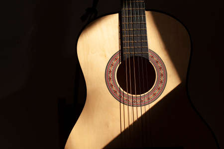 Acoustic guitar. A guitar with six strings. The light falls on the classical guitar.の写真素材