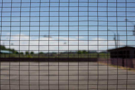 The grid in the stadium. The mesh structure. A metal surface made of wire.の写真素材