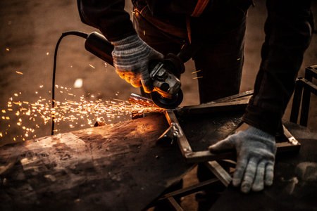 Metal processing in the workshop. Grinding metal. The worker makes the structure of a metal profile....