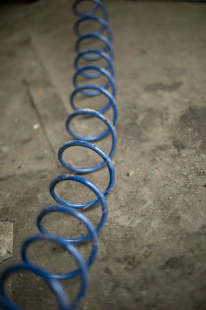 The cable is swirling in a spiral. Cable for compressed air. The hose is blue. Wires on the floor in the garage.の写真素材