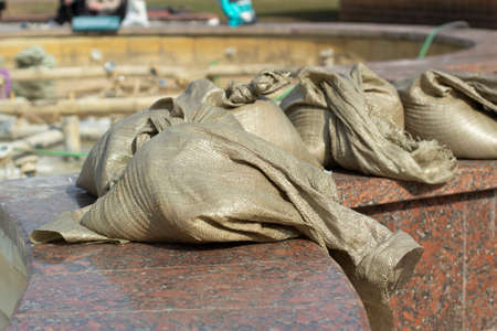 A bag of cement. Solution for construction in a canvas bag. Facing granite in the park.の写真素材