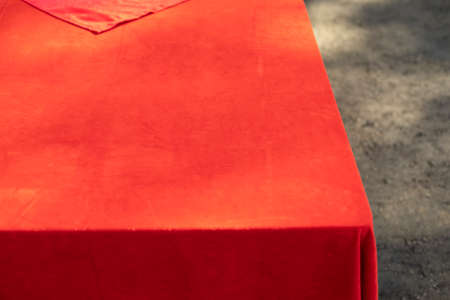 Table with a red tablecloth. Red cloth on a street table. Formal fabric for decoration.の写真素材