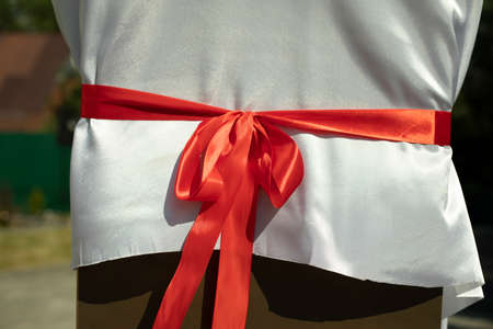 Red fabric bow. Red ribbon on a white cloth. The opening of the monument in detail.の写真素材