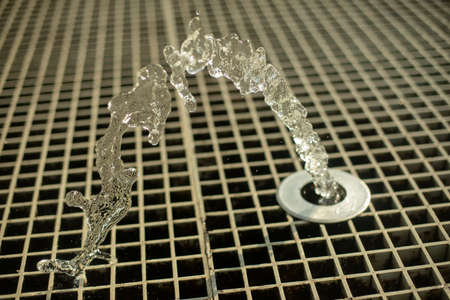 A fountain in the street. Water jets in the summer in the city. Splashing fountain on a sunny day.の写真素材
