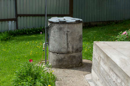 A well with water. A well on the land. Water supply from deep layers of earth. A place of access to fresh water.の写真素材