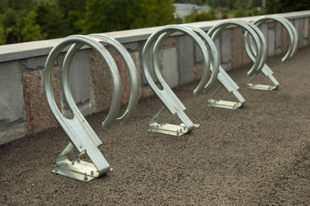 Bicycle parking on the street. A place for attaching street transport. Metal racks for storing bicycles.の写真素材