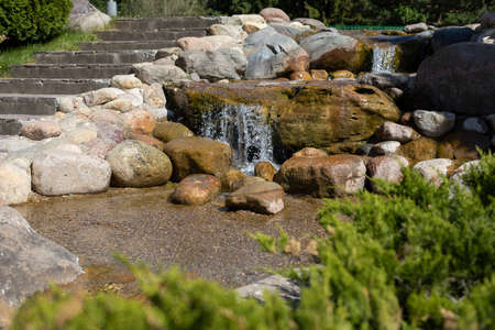 A stream among the stones in the park. Landscaping. Artificial alpine slide. A place to rest.の写真素材