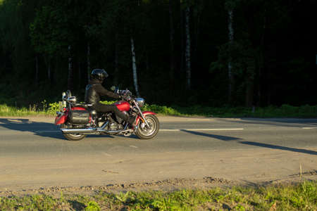 Motorcyclist on the road. A man rides a bike. Motor transport on the highway. The man is riding a two-wheeled vehicle.の写真素材