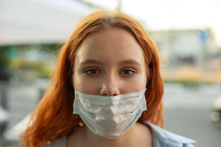 Girl in a medical mask. The teenager put on the mask incorrectly. Portrait of a modern man. The mask is pulled from the nose.の写真素材