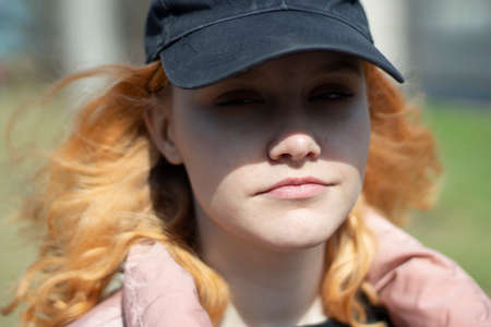 Girl in a cap and jacket. Portrait of a teenager in autumn. Woman in a cap on the street.の写真素材