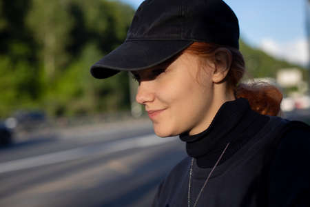 A girl in a police cap. Portrait of a girl in summer sunlight. Teenager on the street. Walking girl at sunset.の写真素材
