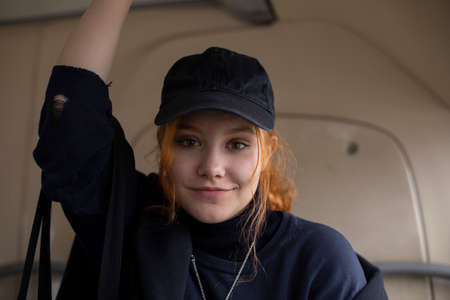 Girl in a cap. The teenager goes on business. Portrait of a girl in a man's cap. Red-haired girl.の写真素材