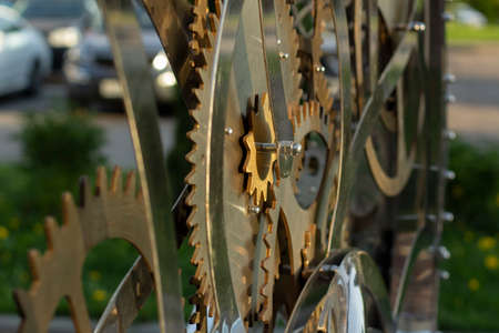 Gears in sunlight. Copper-colored movement. Brass parts with teeth.の写真素材