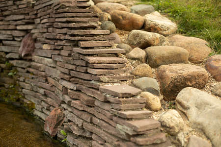 Stone wall in the park. Landscaping from stones. Stone masonry to decorate the territory.の写真素材