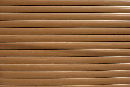 Brown blinds on the street. The texture of the plastic reflective surface. Straight lines in industrial material.の写真素材