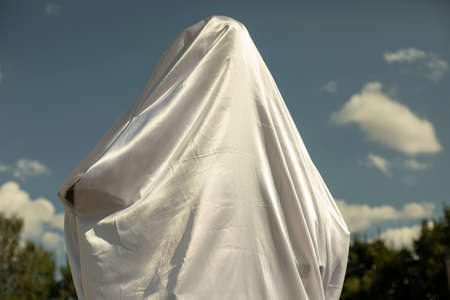 White fabric covers the figure. Opening of the cultural monument. Solemn white fabric on the monument.の写真素材