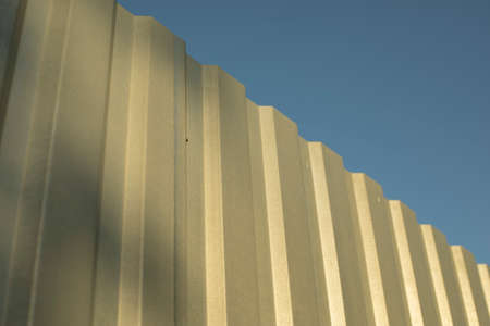 Simple fence made of unpainted metal. Stainless steel fence parts. Industrial design of galvanized material.の写真素材
