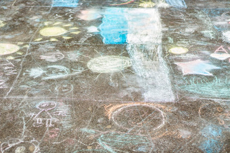 Drawing in chalk on the asphalt. The children painted the asphalt with crayons. A simple background of drawings made by schoolchildren.の写真素材