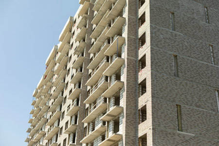 City house under construction. Unfinished multi-storey building. Uncovered facade of the building....