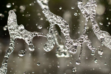 Splashes of water close-up. A jet of fresh liquid pours in the air. Background of large drops of clear water.の写真素材