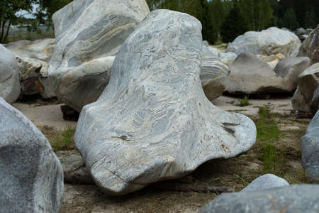 A large stone of unusual shape. White cobblestone. The rock is prepared for installation in the park.の写真素材