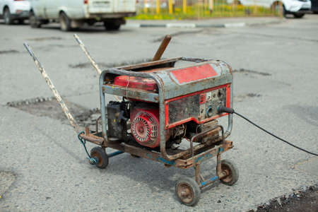 Gasoline generator of electricity. Power supply to the power tool. Generator on the street for road repair.の写真素材