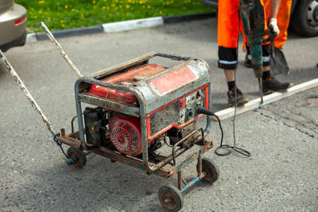 Gasoline generator of electricity. Power supply to the power tool. Generator on the street for road repair.の写真素材