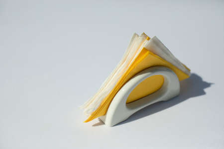 Napkins on a white table. Dinner table setting. Paper napkins in a napkin holder.の写真素材