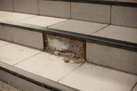 Destroyed facing of steps. Collapsed tiles. Renovation of the facade is required. The cement fell off.の写真素材