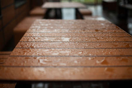 Wet board. Water droplets on the surface. Details of the bench in rainy weather. Wet seat.の写真素材