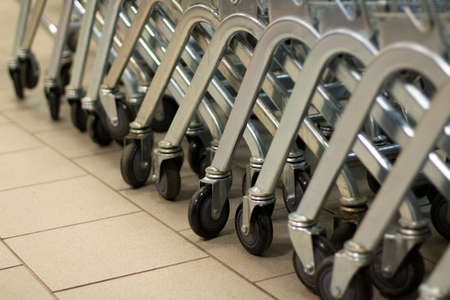 Food baskets are in a row. Carts on wheels. Details of the trading floor in a super layout. Metal trolleys for transportation of goods.の写真素材