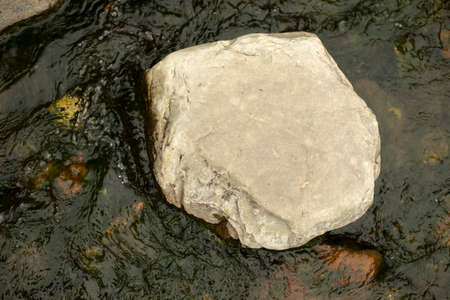Stone in the water. Stone in the middle of the stream. Landscaping in the park. Mountain river details.の写真素材