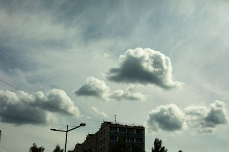 Clouds over the city. Landscape with sky and light clouds. Summer weather.の写真素材