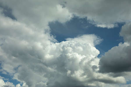 Clouds in the sky. White air masses in the blue sky. Simple background summer weather in the atmosphere.の写真素材
