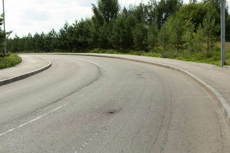 A bend in the road. Asphalt road. Place for traffic.の写真素材