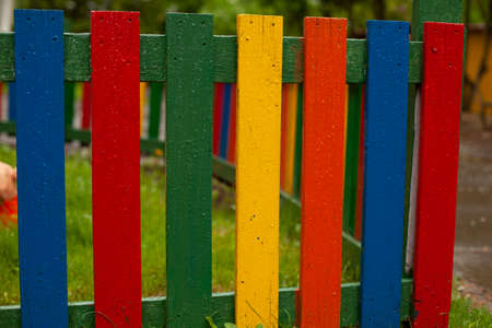 Colored wooden fence made of boards. The fence is painted in different colors. Fencing for children.の写真素材