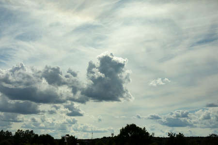 Clouds over the city. Landscape with sky and light clouds. Summer weather.の写真素材