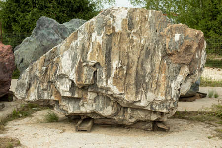 Beautiful stone in the park. A large piece of rock on the street. The cobblestones are prepared for installation in the garden. Sale of stones. Unusual stone.の写真素材