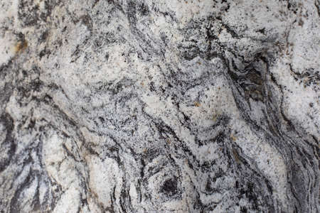 The texture of the stone. The surface of the rock is in detail. Beautiful background natural rock. Gray and white inclusions in hard rock.の写真素材