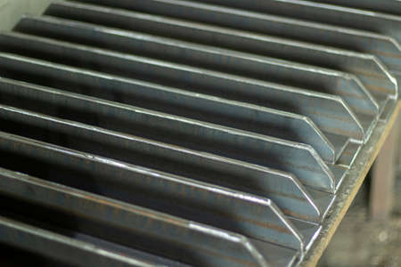 Steel parts lie in a row. Metal products made of strong steel. Industrial material. Items in the metal processing workshop.の写真素材