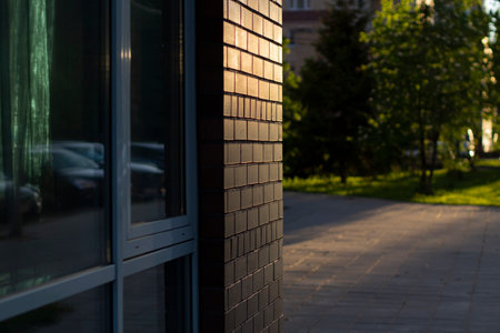 The wall of the building in sunlight. The setting sun illuminates the brick wall. Detail of urban development.の写真素材