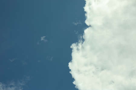 A white cloud in a blue sky. The background is summer weather. Freshness of air on a warm day.の写真素材
