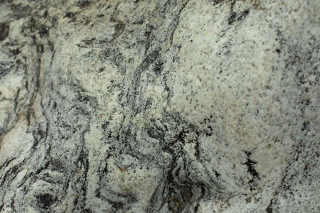 The texture of the stone. The surface of the rock is in detail. Beautiful background natural rock. Gray and white inclusions in hard rock.の写真素材