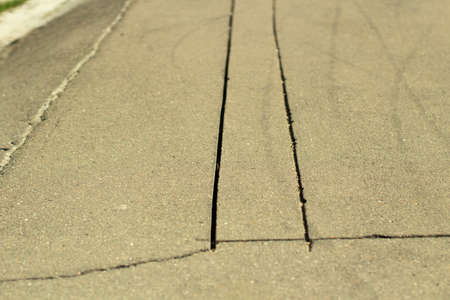 Slots on the asphalt. Sawn asphalt on the road. Two cracks. A sample of material on the highway.の写真素材