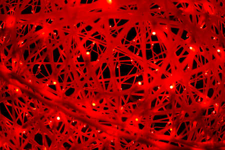 Red LEDs in the web. The texture of the web in bright light. The woven threads glow in the dark. A cocoon of many lines.の写真素材