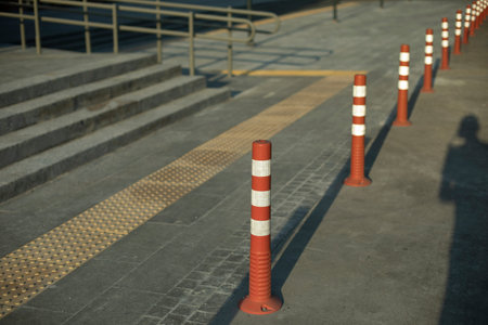 Park posts in the city. Signs restricting the movement of vehicles. Orange white warning sticks to...